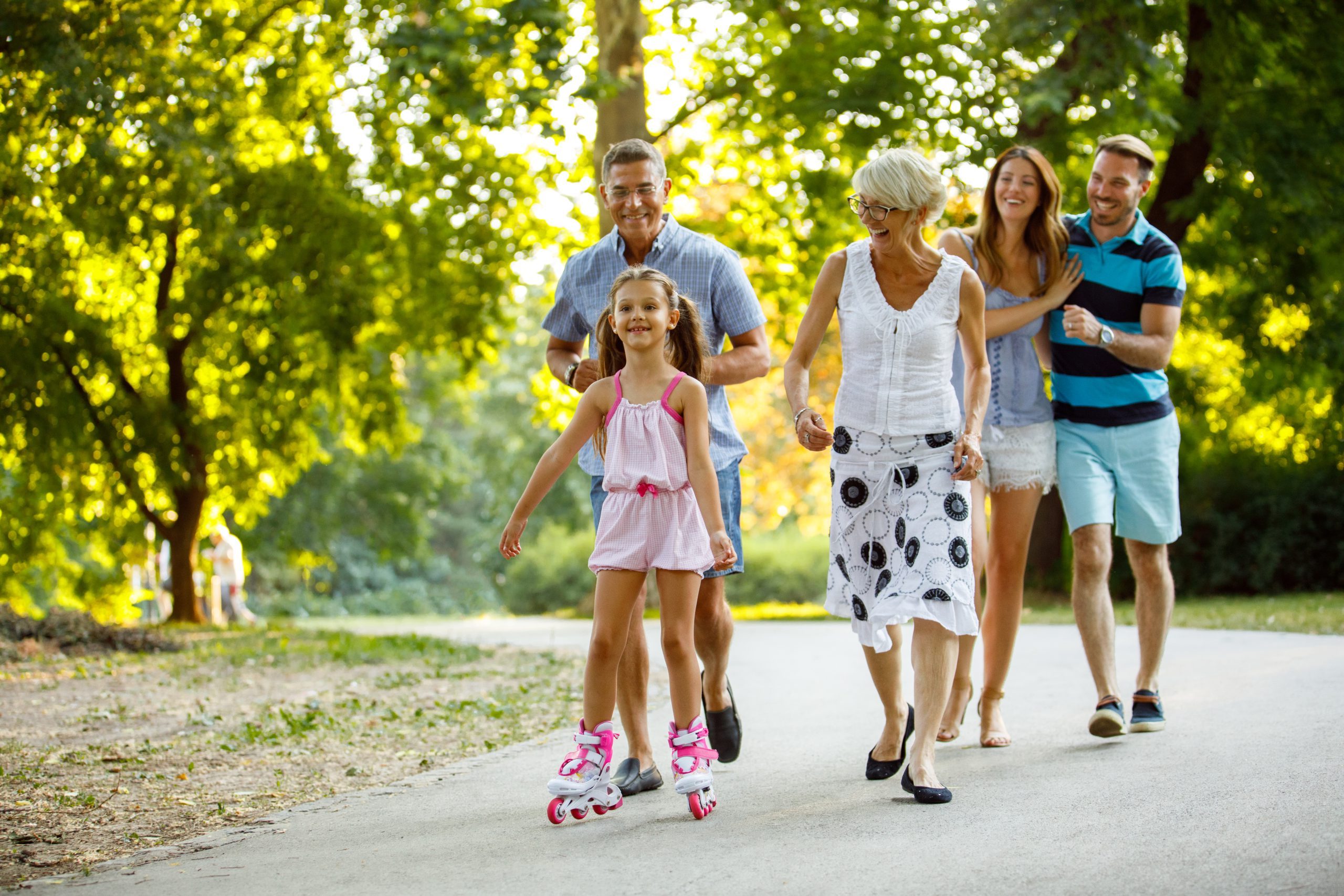 Grandparents assisting their granddaughter while roller skating